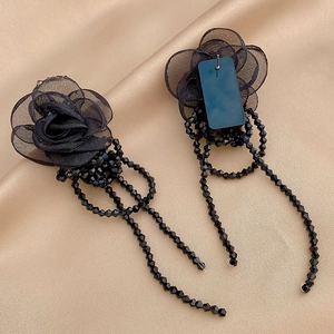 Detailed view of elegant black lace rose earrings with long crystal beaded tassels