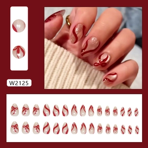 Faux ongles élégants rouge et blanc avec motifs nœuds papillon et lignes ondulées