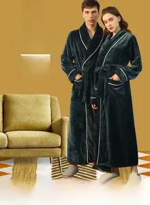 Detail of dark green flannel bathrobe featuring white contrast piping and waist tie closure