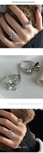 Detail of vintage silver open rings featuring hollow floral and bowknot designs for women