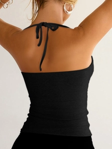Close-up of black ribbed knit Y2K halter top with criss-cross tie-back detailing