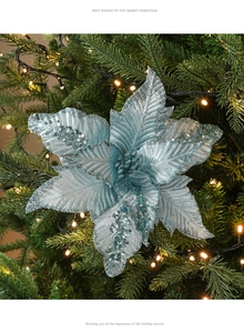 Gros plan d'un poinsettia de Noël bleu glacé scintillant sur une branche de sapin décorée