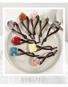 Selection of multi-colored acetate rose hair clips arranged on a beige ceramic plate