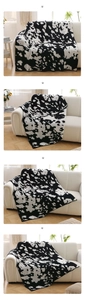 Close-up of soft cow print fleece blanket on white sofa in a modern Nordic living room