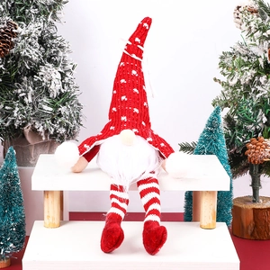 Détail d'un gnome de Noël avec bonnet rouge tricoté et jambes rayées sur fond enneigé