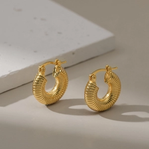 Detailed view of 18K gold plated twisted hoop earrings with elegant textured surface
