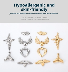 Macro view of assorted stainless steel heart, wing, and cross jewelry charms in gold and silver