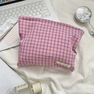 Close-up of pink checkered cotton makeup bag with Sokakka label on white desk