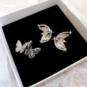 Silberne Flügel-Ohrringe mit Marquise-Steinen und Sternen in einer Schmuckschatulle