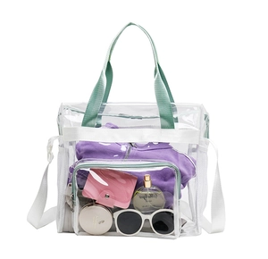 Detail view of transparent PVC beach bag with green handles and white shoulder strap