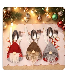 Close-up of three gnome-themed felt cutlery holders with long beards for Christmas table decor