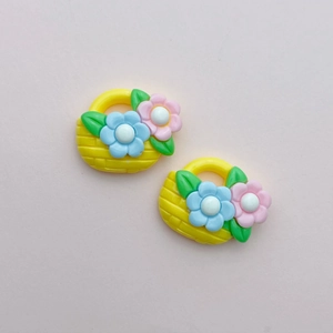 Detailed close-up of yellow resin flower basket charms with blue and pink floral accents