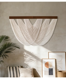 Detail of layered bohemian macrame wall hanging with wooden beam and cotton rope