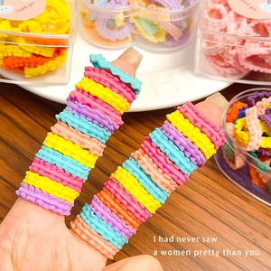 Multi-colored ruffled elastic hair bands for girls in a clear heart-shaped storage box