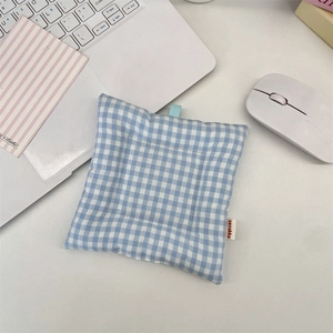Gros plan d'un dessous de verre à carreaux bleus et blancs avec boucle sur table