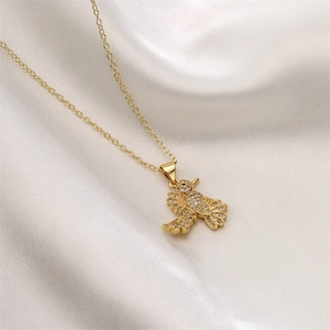 Macro shot of gold-plated bird owl pendant with sparkling zircons on white silk