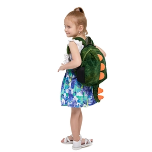 Cute green plush dinosaur backpack with orange spikes worn by a child on white background