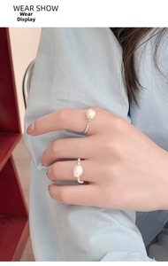 Detailed view of elastic silver bead ring featuring a natural baroque pearl on model hand