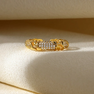 Macro shot of gold-plated adjustable ring featuring pavé-set zircons and twisted rope texture