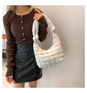 Detailed shot of a white quilted puffer bag with a knotted strap and bubble texture