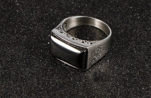 Macro view of men's stainless steel ring featuring a rectangular black zircon gemstone inlay