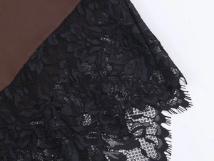Detailed close-up of brown satin fabric joined with intricate black eyelash lace texture