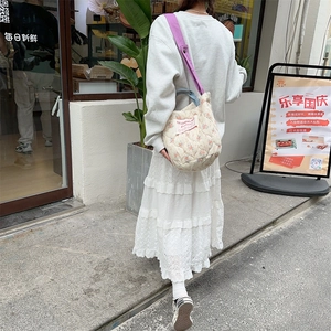 Sac à main matelassé à fleurs avec bandoulière violette porté en style urbain