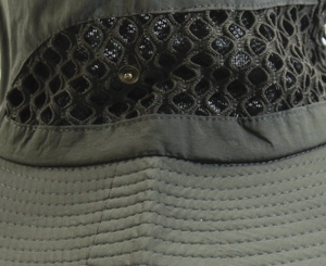 Détail d'un chapeau de soleil vert olive montrant maille, bouton et coutures