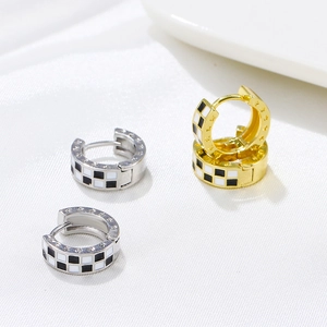 Detailed shot of checkerboard enamel hoops with star engraving on silk background