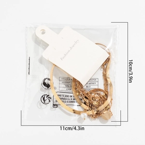 Detail of gold snake chain necklace with pearls and tags in clear packaging
