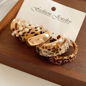 Detailed set of leopard print and pearl earrings displayed on a fashion jewelry card