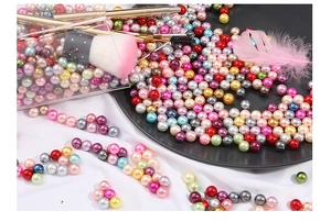Close-up of colorful 3-10mm ABS imitation pearls in various vibrant metallic finishes