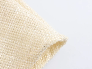 Detailed macro view of beige tweed fabric texture on a French style fishtail dress