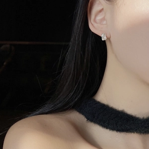 Close-up of minimalist S925 sterling silver baroque pearl earrings on female model