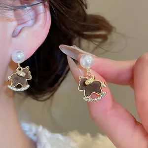 Elegant pearl rocking horse earrings with flocking detail and sparkling crystal accents