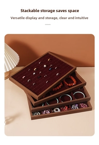 Detail view of stacked walnut wood jewelry trays with deep red velvet lining