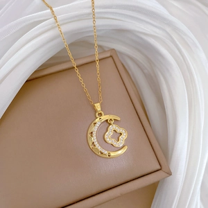 Elegant gold titanium steel moon and clover necklace with diamonds on a jewelry box