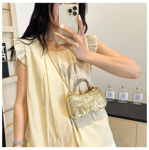 Detail of gold sequin evening bag with metallic shell texture and crossbody chain strap