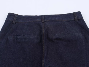 Dettaglio di pantaloni in denim blu scuro con cuciture gialle a contrasto e tasca posteriore
