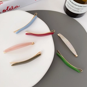 Minimalist acetate hair clips set in various candy colors on a modern display surface