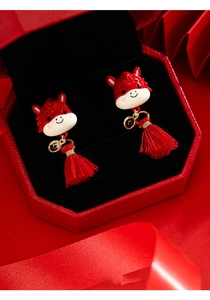 Detail view of red zodiac horse earrings with golden coins and red silk tassels
