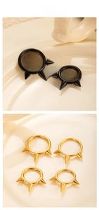 Detailed view of G23 titanium hoop earrings with three spikes in black and gold finish