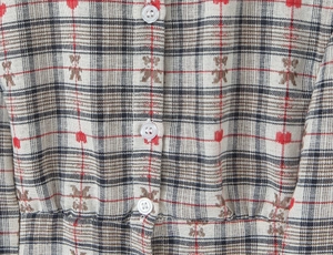 Detailed macro view of plaid fabric with white buttons and bear print pattern