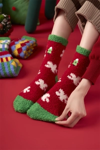 Close-up of thick coral fleece Christmas socks with festive tree and snowflake patterns