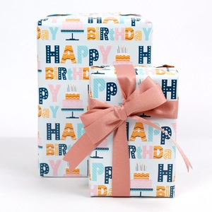 Eco-friendly birthday gift wrapping paper rolls featuring cake patterns and happy birthday text