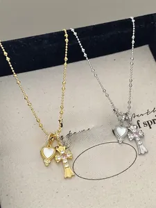 Makro-Detail von Kreuz- und Herzanhängern an Kugelketten in Gold und Silber-Optik