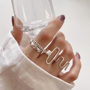 Macro shot of 925 sterling silver geometric rings set on finger in a lifestyle setting