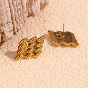 Close-up of geometric 18K gold plated hollow mesh rhombus stud earrings on stone base