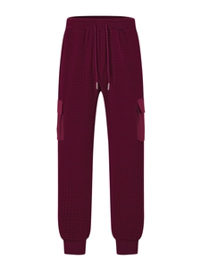 Detailed close-up of dark wine red quilted cargo pants with textured waffle fabric