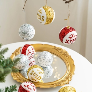 Glittery gold, silver, and red Christmas tree ornaments with XMAS painted text decor